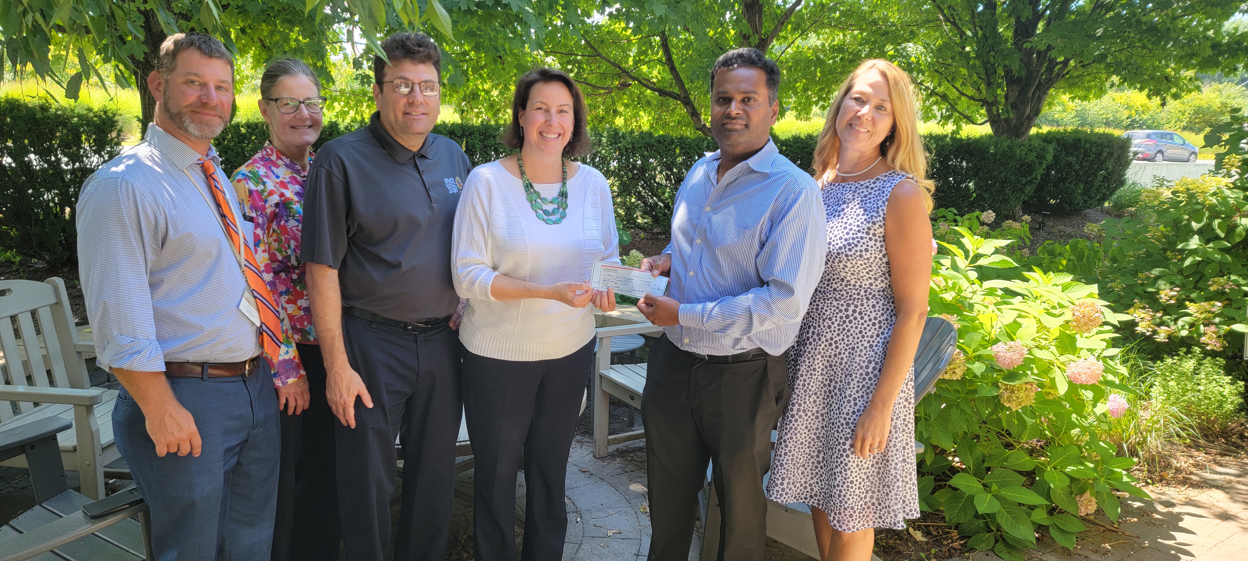 Mahesh Parusha presenting a donation check to Howard County school representatives