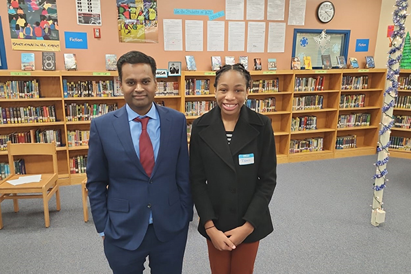 Two people standing together in a school library